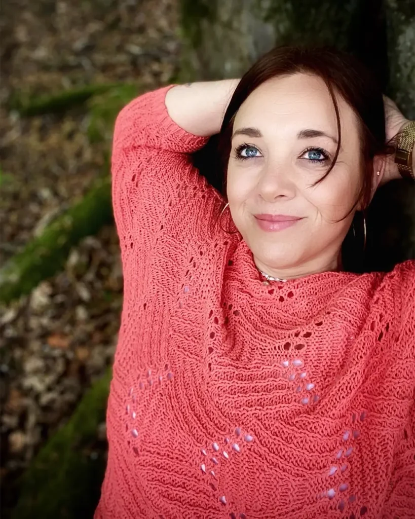 Tine Sattler rosa Pullover im Wald blickt in die Ferne